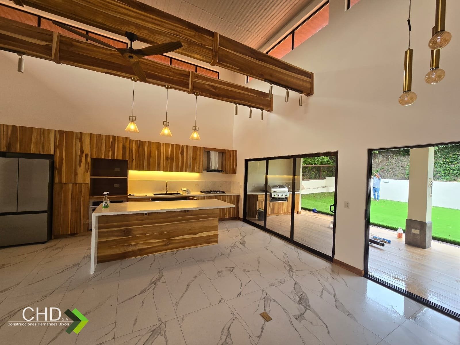 Cocina con isla y vigas de madera terminada por CHD