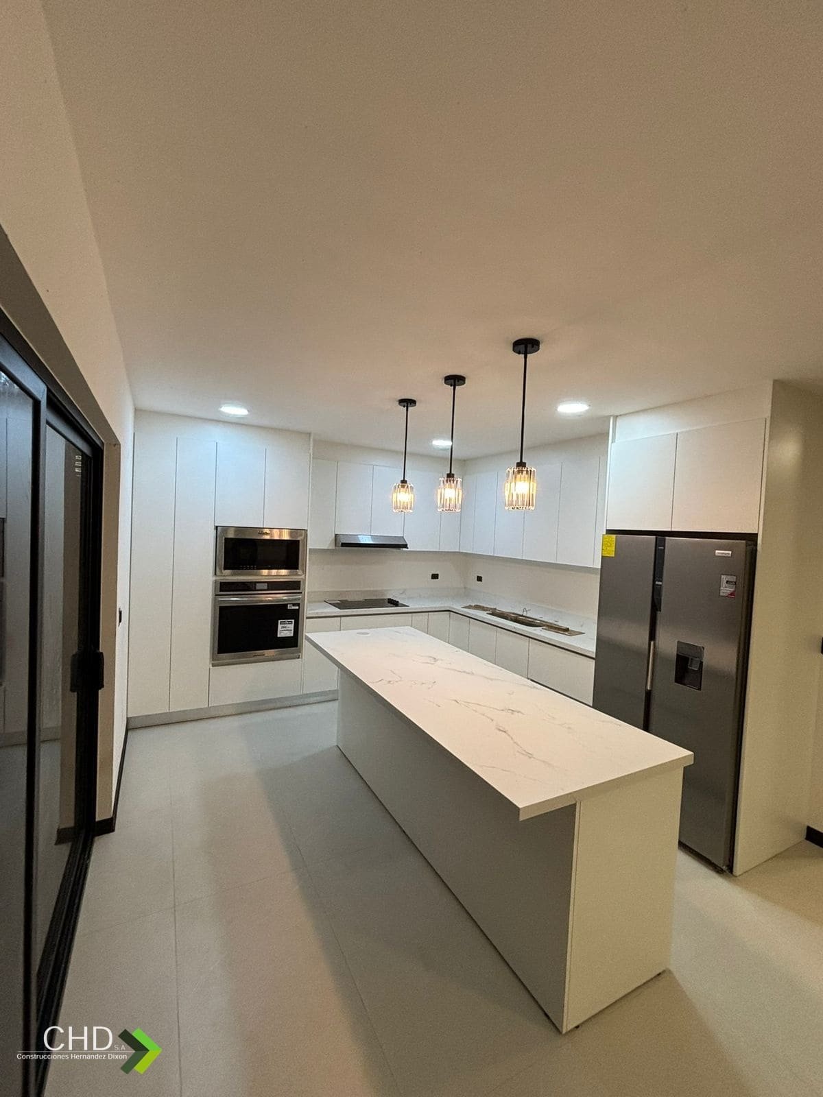 Cocina remodelada por CHD con isla y muebles blancos