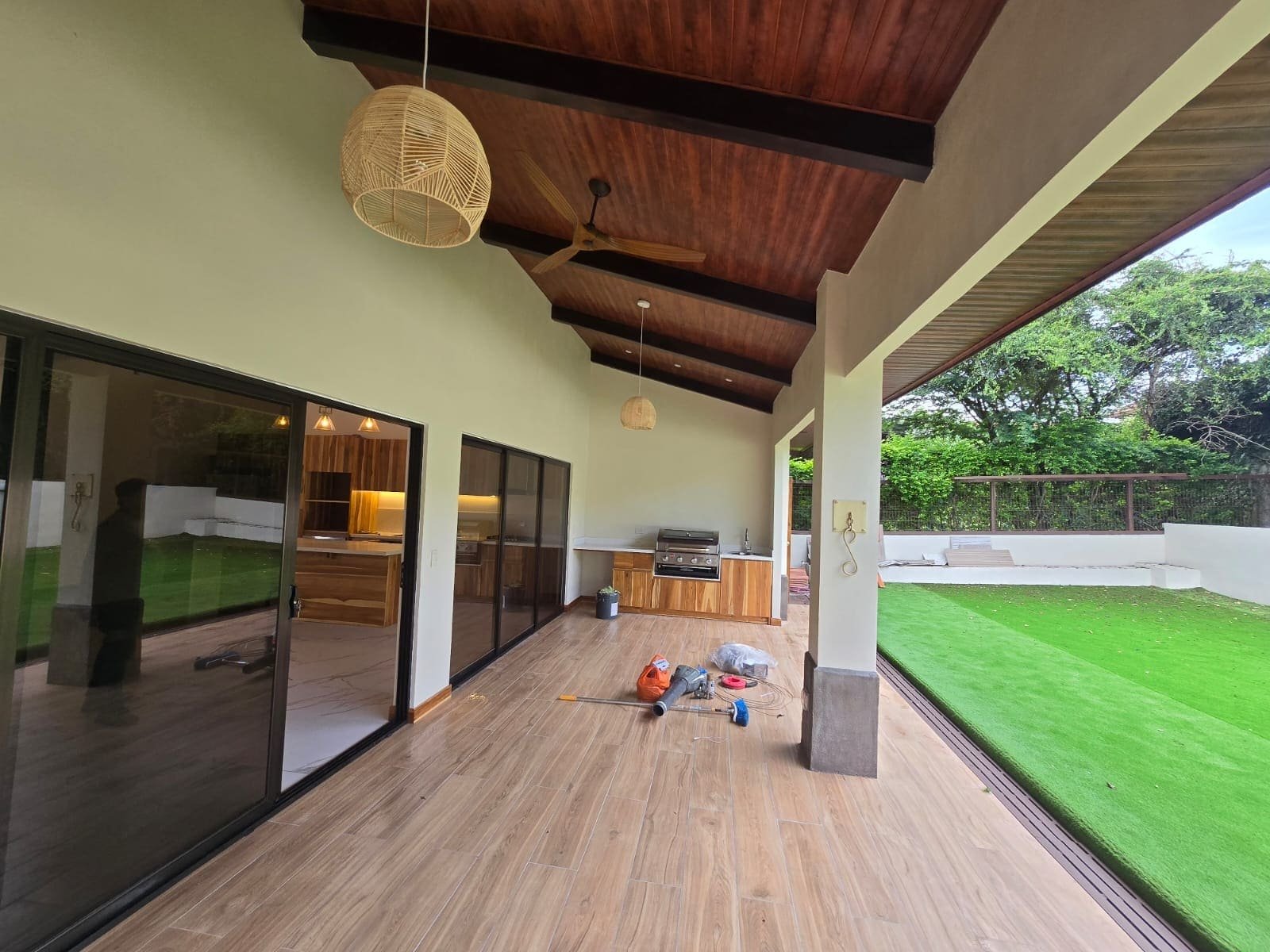 Terraza techada con cielo de madera y piso laminado en una obra de CHD