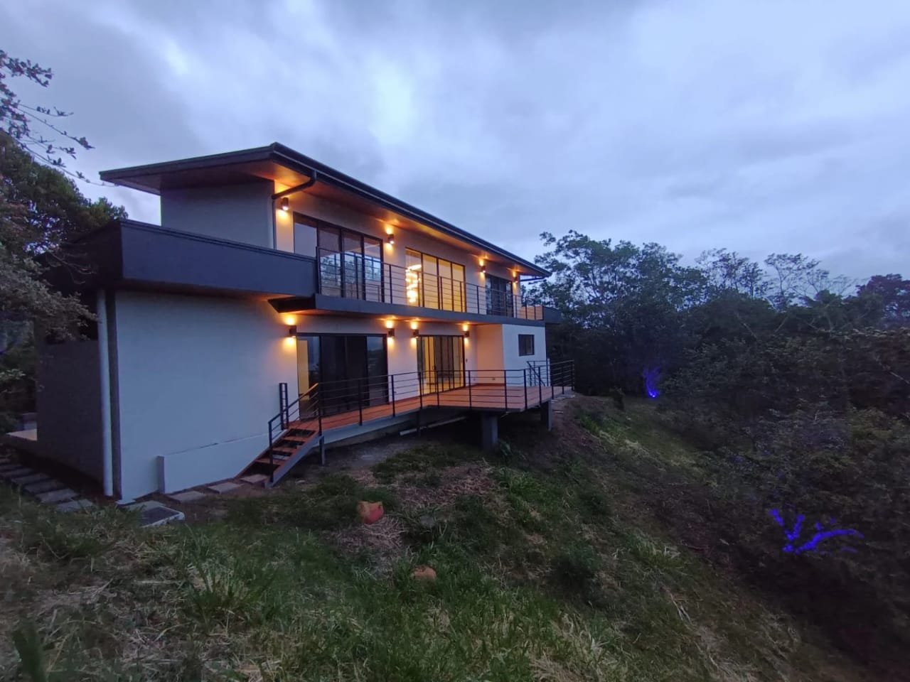 Casa de dos niveles construida por CHD, iluminada de noche