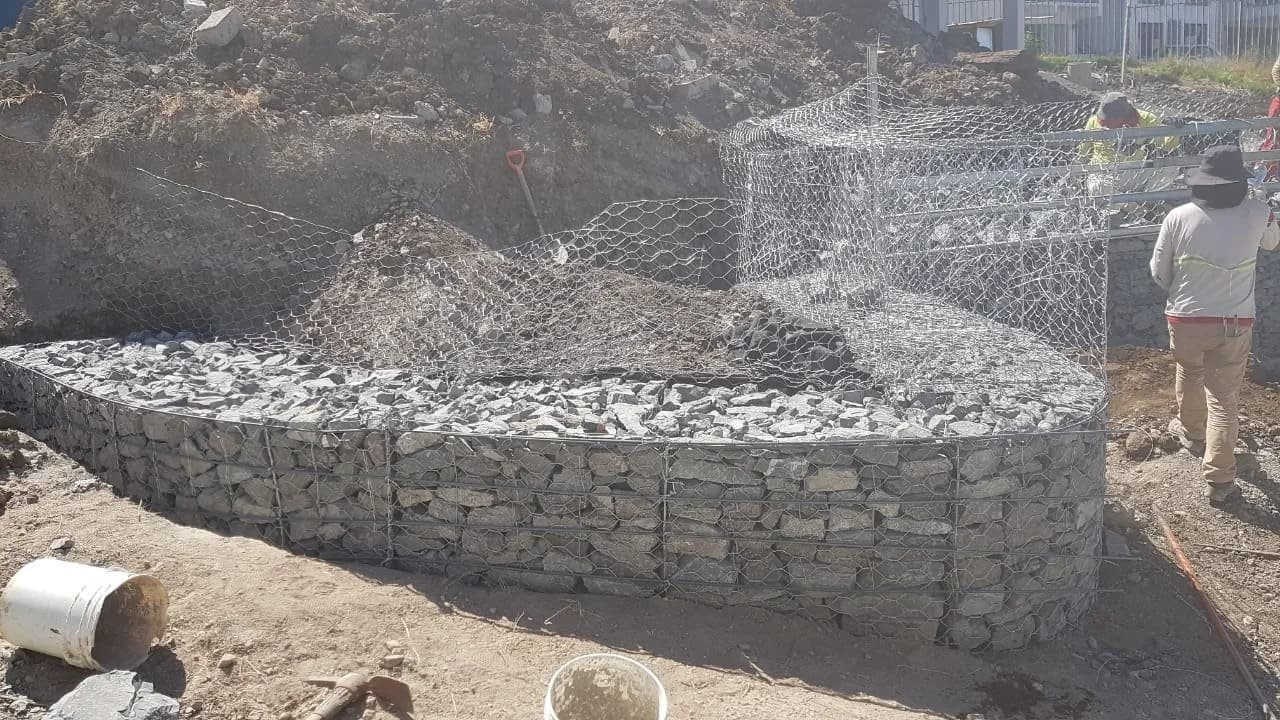 Gaviones curvos en construcción, rellenos de piedra, en un terreno inclinado